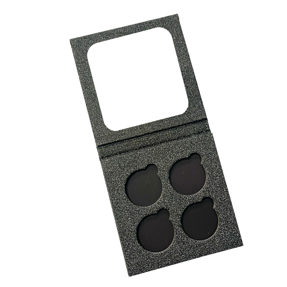 A 4-pan custom eye shadow palette with a gray texture and four black pressed powder piles.