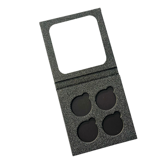 A 4-pan custom eye shadow palette with a gray texture and four black pressed powder piles.